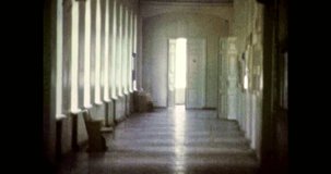 Long corridor of educational institution, university, school. Bright, empty room with large open windows. Nobody in building. Interior of long hallway inside. Vintage color film. Retro archive 1980s