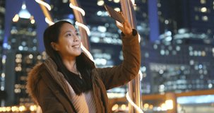 Woman taking photo with smart phone in the city of Hong Kong, tourist visit Hong Kong, building bokeh city background