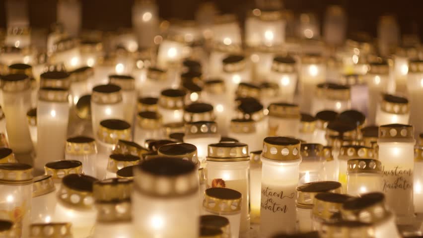 Candle lights on graves and tombstones at a cemetery. Lit candles illuminate the graves at a Christian cemetery at night. In the memory of victims of the war in Ukraine Royalty-Free Stock Footage #3405802653