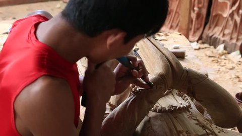BAGAN. MYANMAR - JANUARY 22, 2016: Burmese man are making wooden souvenirs for tourists in Bagan, Myanmar. Wood Carving is a traditional handicraft in Myanmar