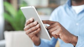 Close up of male hands holding and typing on digital tablet. African american man is using device in living room at home. Male browsing social networks, shopping online, chats, writes messages swiping - Powered by Shutterstock - Get 15% off with code: PIKWIZARD15