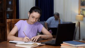 A teenage girl talking to her teacher- instructor on a video call using a laptop - distant education, e-learning. A young Indian school kid taking online classes - sincere student, exam preparatio...