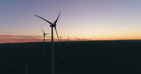 Aerial wind farm turbine generators at dusk. Clean renewable energy power production concept. Algarve countryside. Portugal.