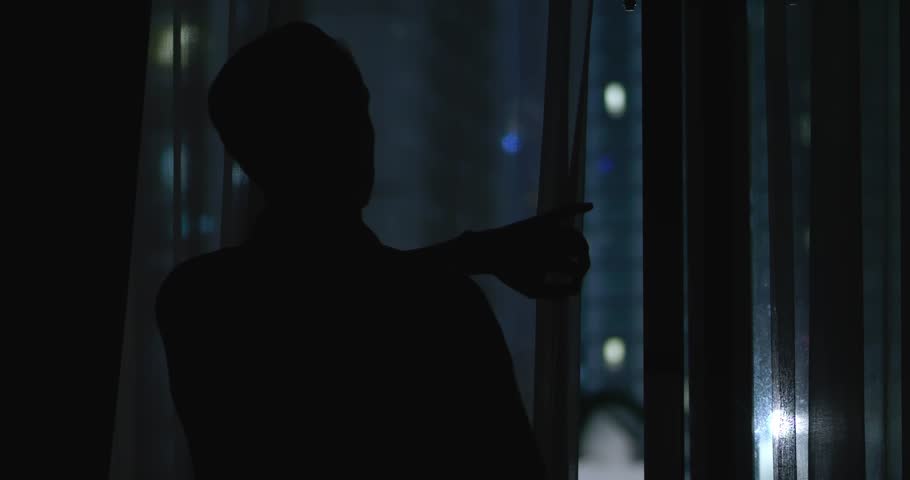 Man pulls curtain unveiling vibrant life of modern city at night. Beautiful view from window canvas of lights and energy In this moment view from window inspires awe and reflection. Royalty-Free Stock Footage #3406088427