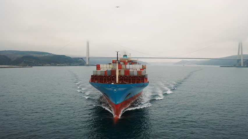Prow and container loaded foredeck of the ship underway. Bulbous bow breaking the waves. Aerial frontal view as a cargo ship ploughs through calm waters of Bosporus Sea. Vessel heading towards camera
 Royalty-Free Stock Footage #3406099267