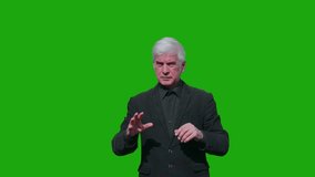 An elderly man in a suit scrolls through a virtual screen on a green background. Chromakey. 