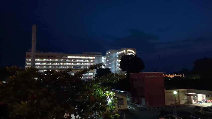 HOSPITAL HSNZ, KUALA TERENGGANU, MALAYSIA - OCT 16, 2023 : A time lapse with view of sunrise. Hospital, people and traffic as part of the scenery