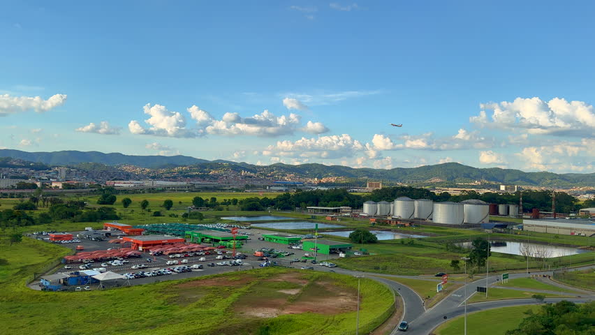 Plane Taking Off from Guarulhos International Airport (aka Cumbica Airport), São Paulo - Brazil. Landscape View from the End of the Runway with Guarulhos City on the Background. 