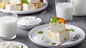Cottage cheese casserole with raisins and cup of milk on wooden grey background. Cottage cheese casserole