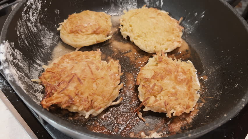 Flipping flapjacks on hot frying pan. Cooking potato pancakes at home. POV turn over battercakes. Crispy morning snack. Film grain pixel texture. Soft focus. Blur. Live camera Royalty-Free Stock Footage #3406333329