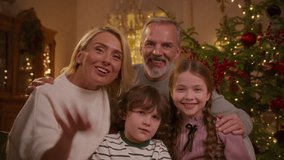 family makes video call to far distance relatives on holidays to wish merry Christmas, sitting on couch near Christmas tree. wave hello, smile and tell stories - Powered by Shutterstock - Get 15% off with code: PIKWIZARD15