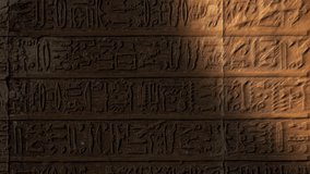 Light spot moving on ancient egypt hieroglyphics carving on wall of temple. Vertical video