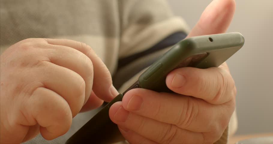 People communication: Seniors use mobile phones to stay connected with family, friends, and loved ones through calls, text messages, and instant messaging apps. Close-up hands with smartphone.