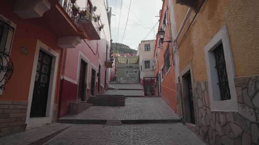Walking on Small Narrow Street Alley with Colorful Buildings in Guanajuato, Mexico