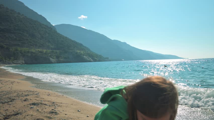 The girl making stone pyramid on a sand beach. 4k slow motion footage UHD 3840x2160 