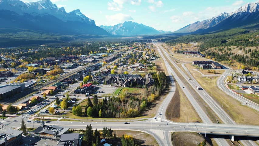 Aerial view of Trans-Canada Highway (Highway 1) exit 89 to Downtown Canmore in Canadian Rockies in a autumn sunny day. Alberta, Canada. Transportation concept. Royalty-Free Stock Footage #3406924373