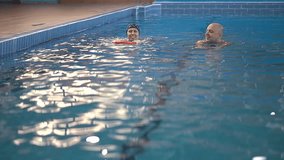 a man and a woman are swimming. adults in the pool. Slow-motion video. woman in a swimming cap. High-quality shooting in 4K format