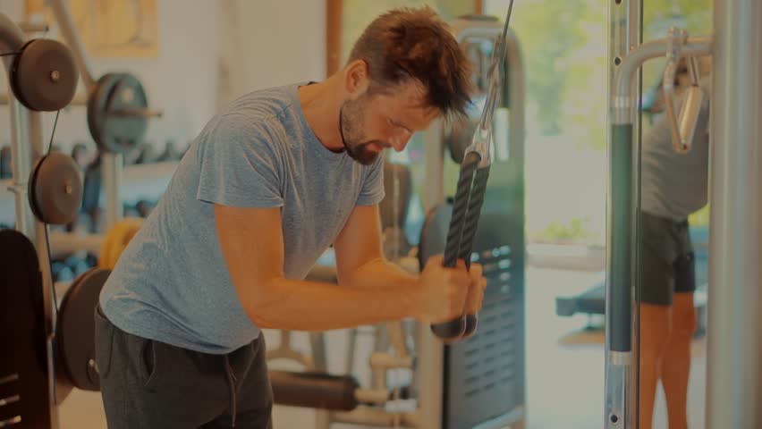 Multi-gym Sport Workout.Chest Workout Pull Down Machine. Sport Recreation Bodybuilding Lifting Weight. Fitness Exercising Sport Gym. Triceps Pushdown. Weight Lifted Exercising In Gym Pull Down Machine Royalty-Free Stock Footage #3407012041