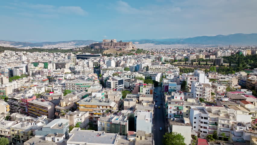 Aerial view of Ruins of the iconic temple complex Acropolis of Athens on a rocky hilltop in Greece. View from above the old Athens buildings and Historical landmark Parthenon on archaeological site.
