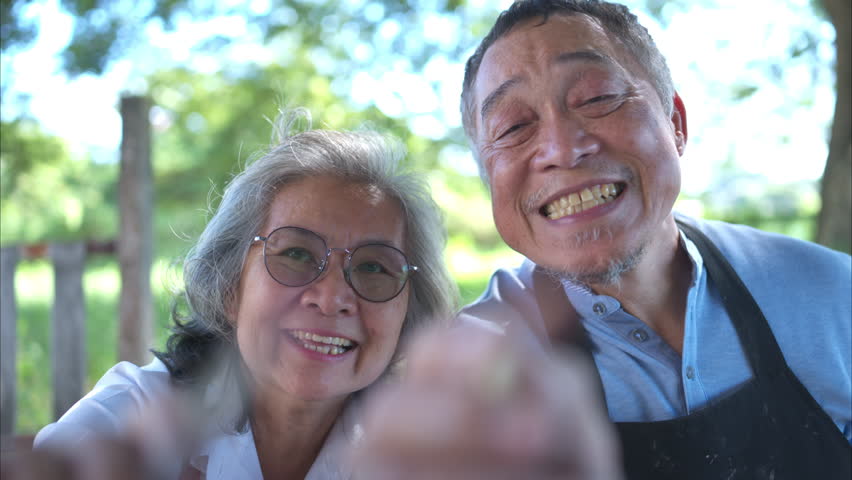 In the pottery workshop, an Asian retired couple is engaged in pottery making and clay painting activities.