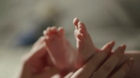 Tender touch of mother's hand on her newborn baby's chubby bare feet, peaceful and serene moments of parenthood and beauty of motherhood. Adorable baby and happy family. Cinematic advertisement - Powered by Shutterstock - Get 15% off with code: PIKWIZARD15