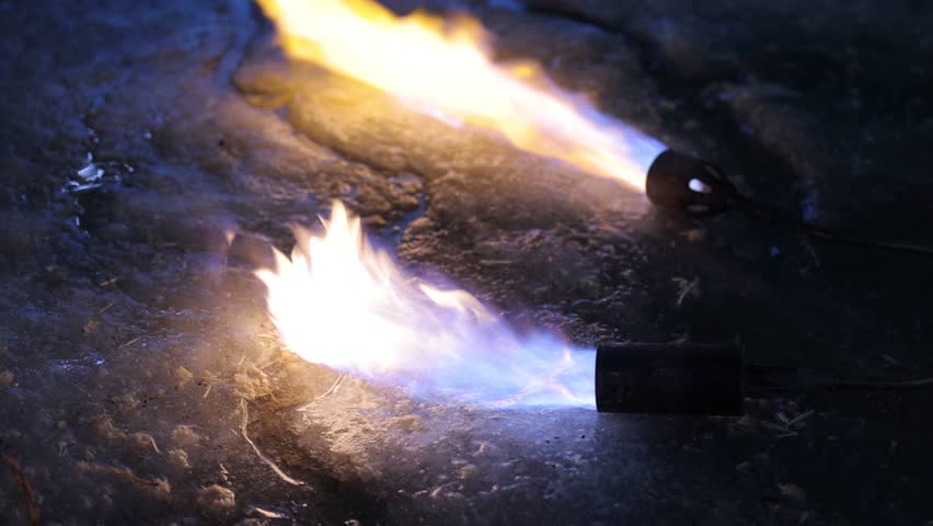 A fiery stream from a kerosene torch to snow and ice
