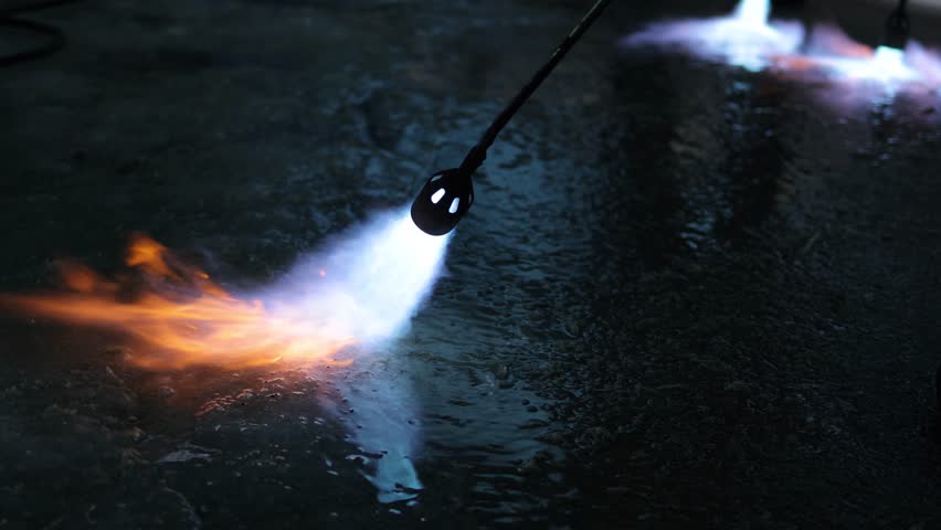 A fiery stream from a kerosene torch to snow and ice