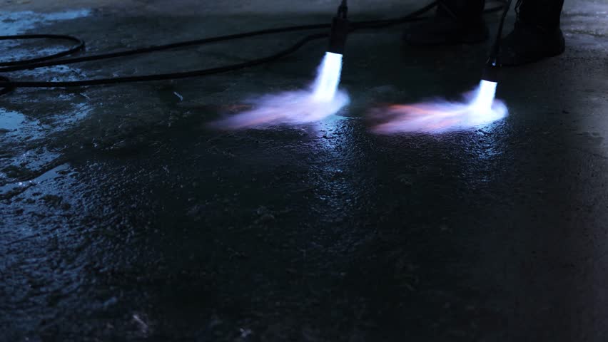 A fiery stream from a kerosene torch to snow and ice