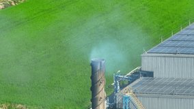 Industrial plant smoke, laden with harmful pollutants, poisons the air, posing grave health risks and contributing to climate change, demanding urgent action. Aerial view drone. Cinematic footage.
