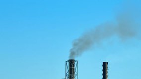 Environmental Hazard: Black plumes from a factory pollute the azure sky, exemplifying the urgent need for eco-friendly practices. Atmospheric Aerosols and Lung Health concept. Aerial view drone. 4K.
