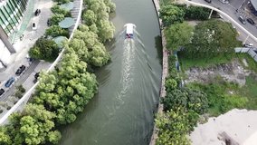 Aerial video of tourist boat cruising along a river captured by drone