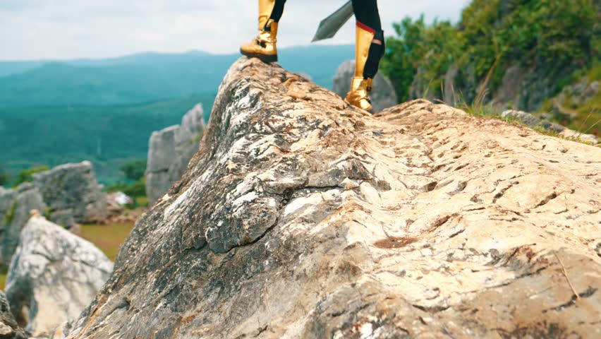 a female warrior holding a sword and golden shield standing on a cliff very bravely in the daytime