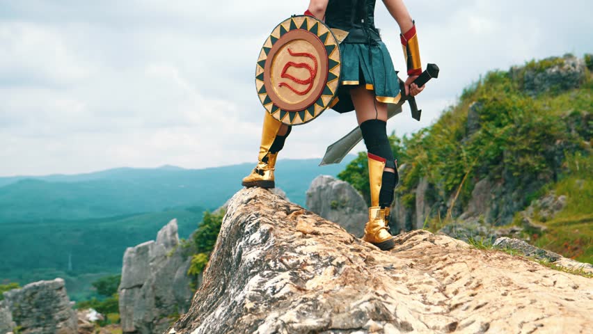a female warrior holding a sword and golden shield standing on a cliff very bravely in the daytime