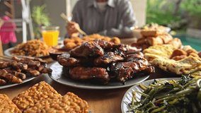 Eating Fresh Meal of Traditional Asian Food on Family Table. Cooking Healthy Delicious Cuisine in Asia Style. Indonesia Woman Sits with Yummy Appetizers of Various Seasoned Meat and Stir Fried Noodles - Powered by Shutterstock - Get 15% off with code: PIKWIZARD15