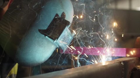 worker welding steel with mig welder machine slow motion