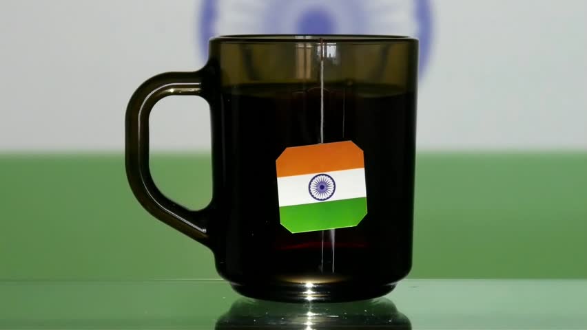 Close-up of a cup of tea with an Indian flag tag and a man's hand takes it Royalty-Free Stock Footage #3408000011