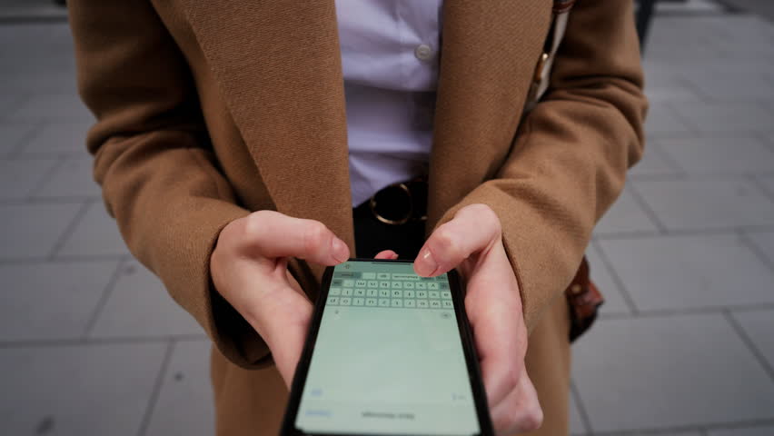 Closeup hands of young business woman texting sms on mobile phone with vertical screen