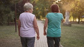 Back view of two women walking in the park - Powered by Shutterstock - Get 15% off with code: PIKWIZARD15