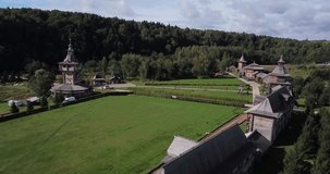 4K summer morning aerial footage of green forest, church complex and hotel bungalows