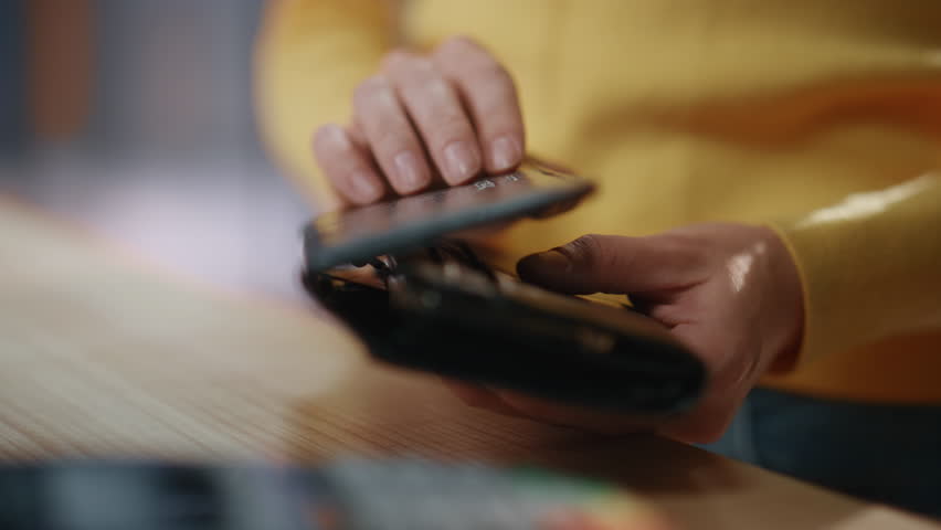 Closeup woman hands paying with credit card over terminal at store. Unknown lady making contactless payment using wireless system technology in mall. Happy client taking purchases feeling grateful