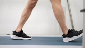 Close-up video of the legs of a man walking on a treadmill during a cardiac stress test