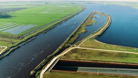 Long Shot of Cargo Ship Crossing an Aqueduct on Peaceful Dutch Flat Landscape - Friesland, The Netherlands 4K Drone Footage
