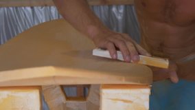 Close up of shaper sanding the wooden surfboard - Powered by Shutterstock - Get 15% off with code: PIKWIZARD15