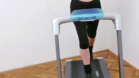 Young woman exercises and keeps fit on a treadmill at home, Video Clip 4K