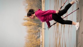 Nordic walking. Fit chubby woman with nordic walking poles training in the morning for competition and marathon. Wellness concept. Young female with large build exercising outdoor. Vertical video