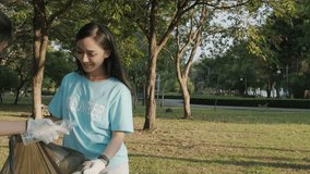 Two female volunteers with garbage bagcollecting trash in the public park. Environmental protection and charity concept - Powered by Shutterstock - Get 15% off with code: PIKWIZARD15