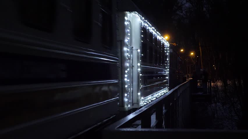 Christmas Children's Train with Blinking Lights riding on the Bridge in the Winter Park
