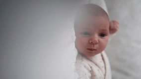 focus transition beautiful child lies in bed and waves his hands. vertical video. a baby in a playpen. close-up