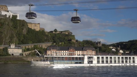 KOBLENZ, GERMANY - SEPTEMBER 15, 2017: River cruise ship sails on River Rhine past Ehrenbreitstein castle. It has been a UNESCO World Heritage Site since 2002.