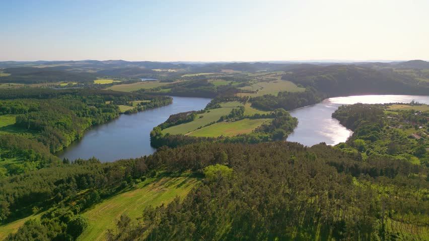Curves of Vltava river in green landscape on sunny summer day. Aerial 4K footage from above
